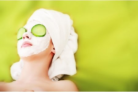 Image of a girl with face mask and cucumber on her eyes